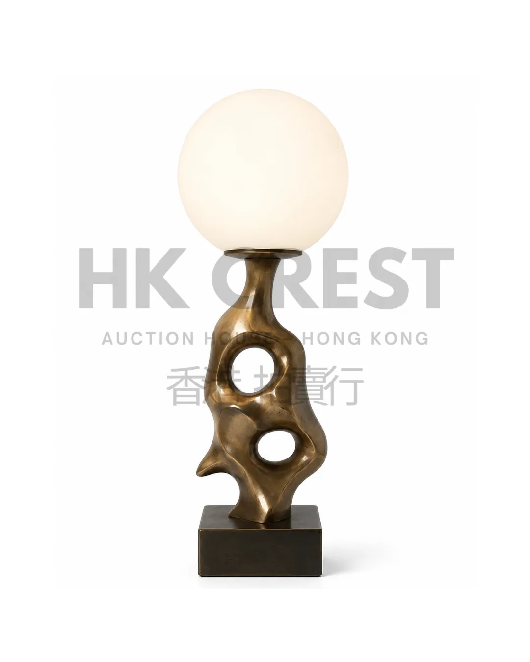 Sculptural table lamp with a dark bronze-finished arching base and an opal glass globe…
